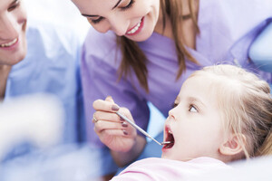 Tannlege undersøker tennene til et lite barn